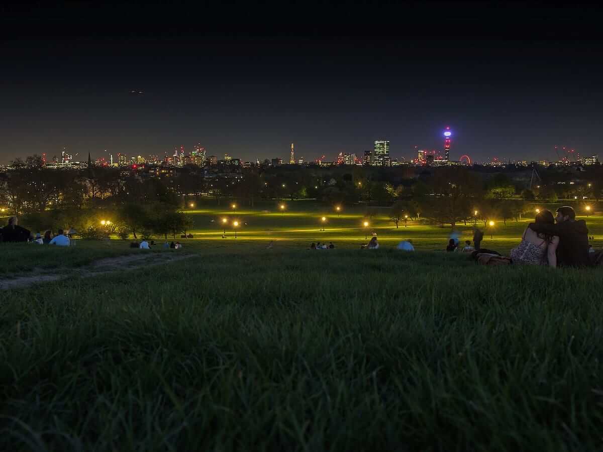 a view of downtown london at night from primrose hill in london