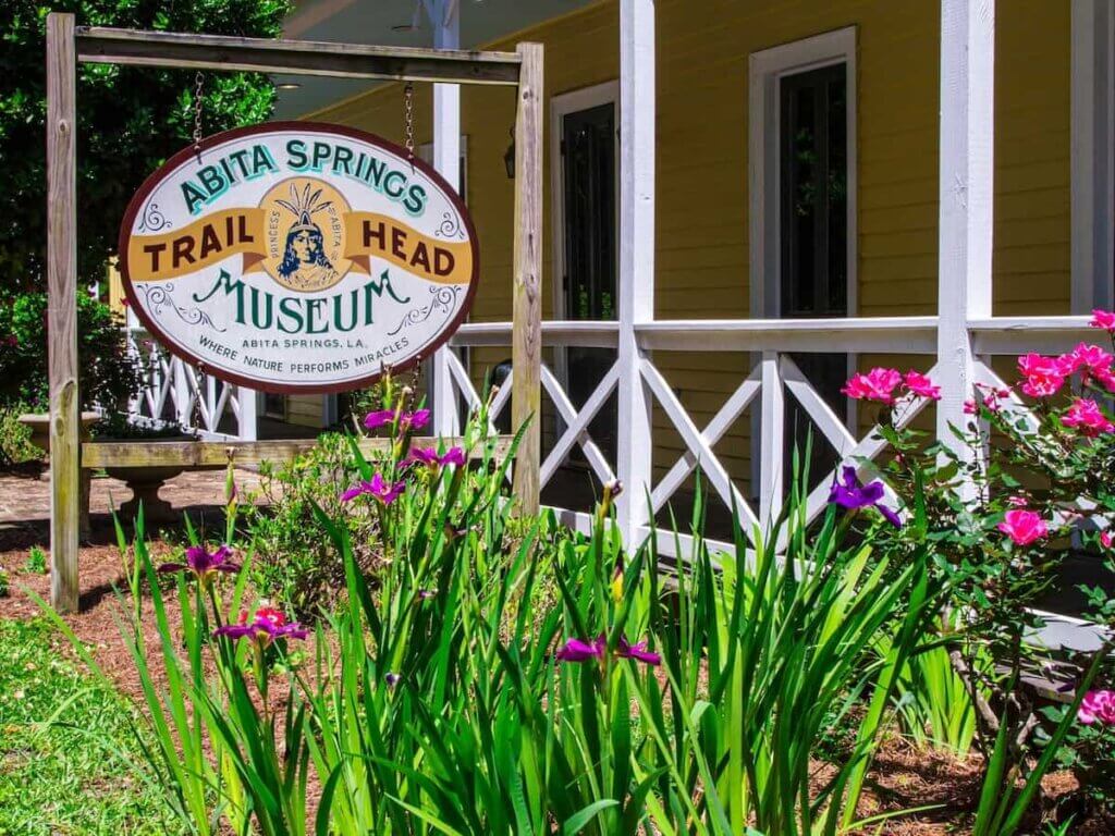 a sign for the abita springs trail head museum